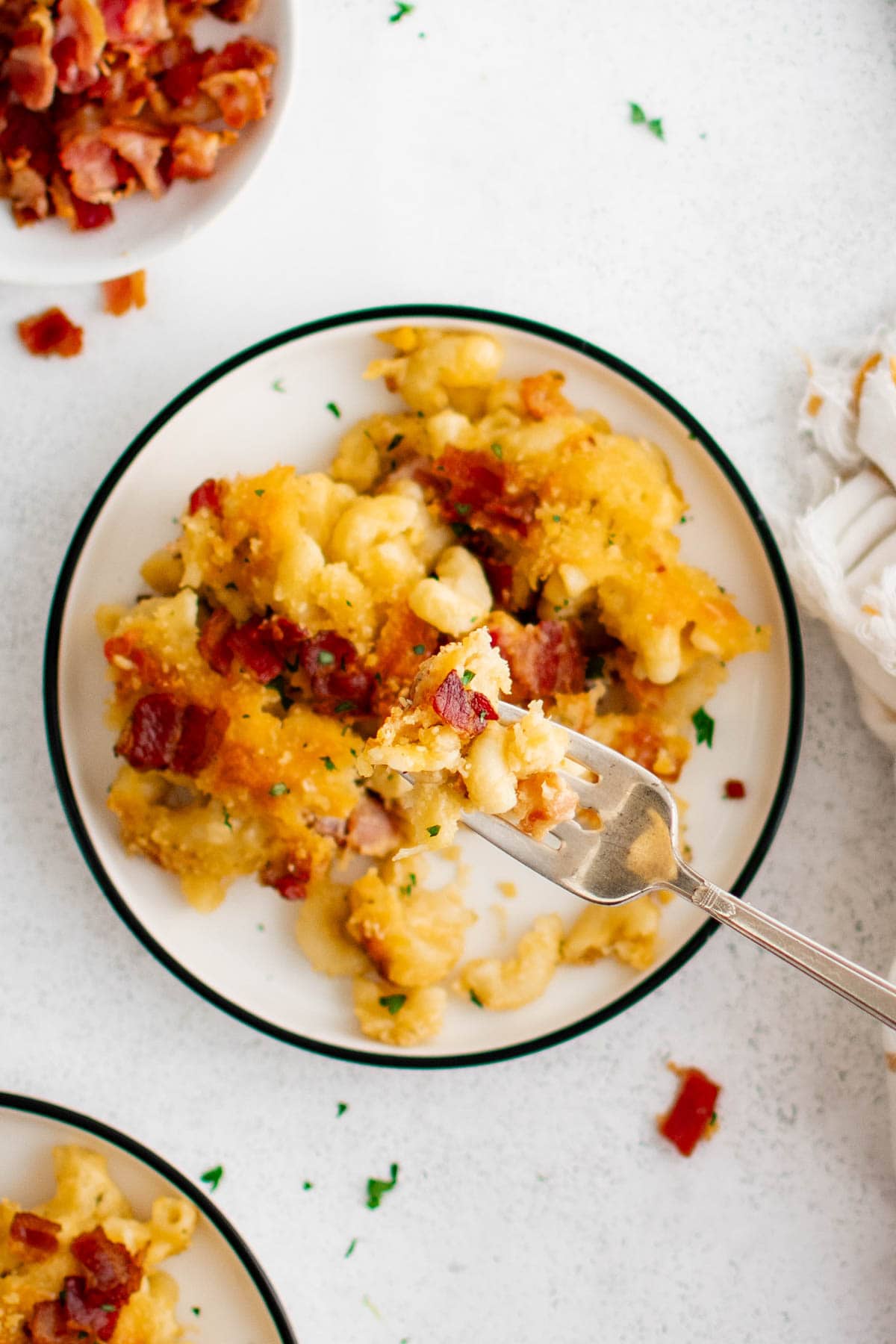 Dish with mac and cheese with bacon, a fork.