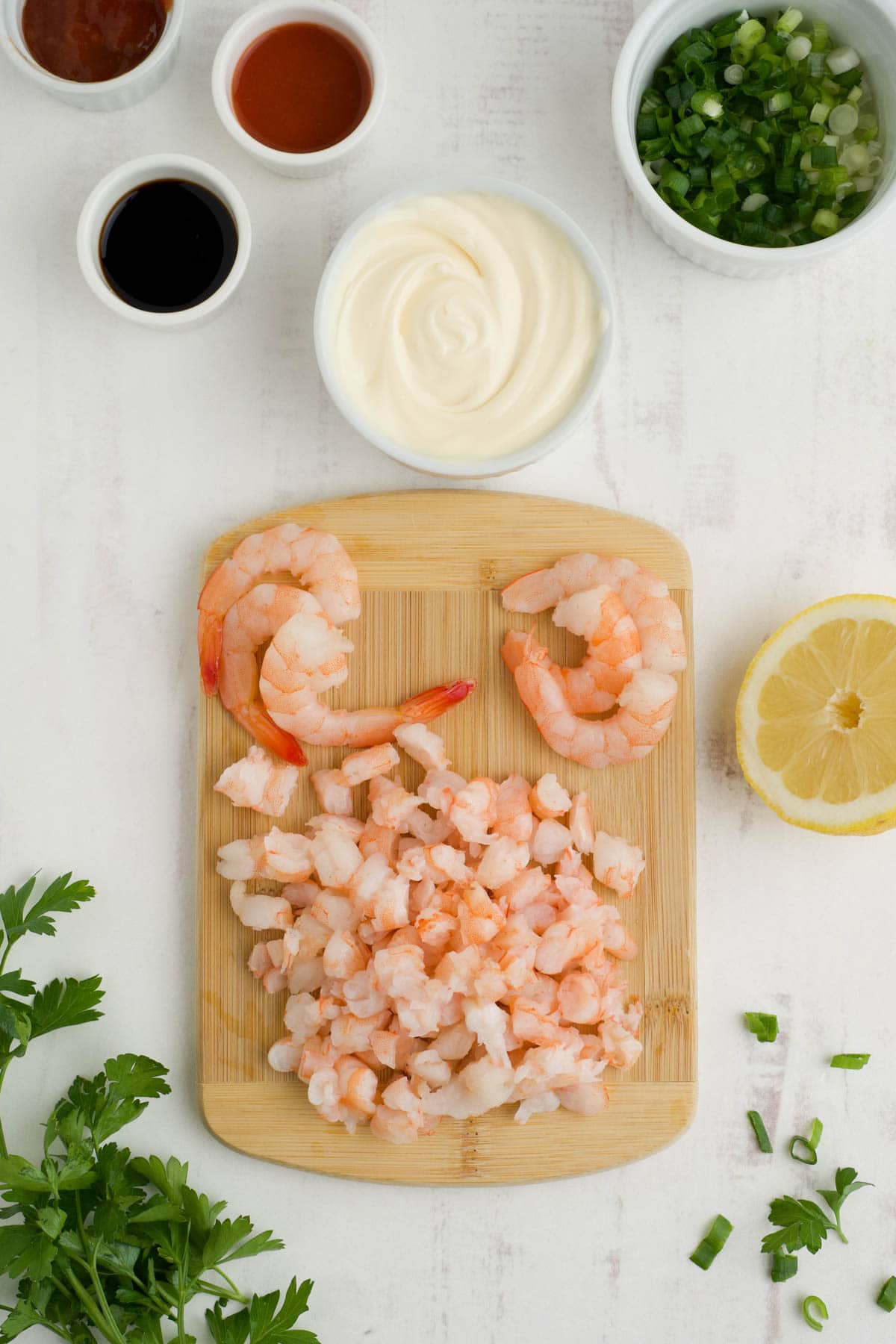 Chopped up shrimp on a cutting board.