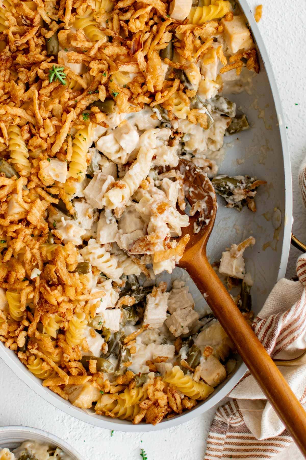 Fried onion on top of chicken casserole in a baking dish.