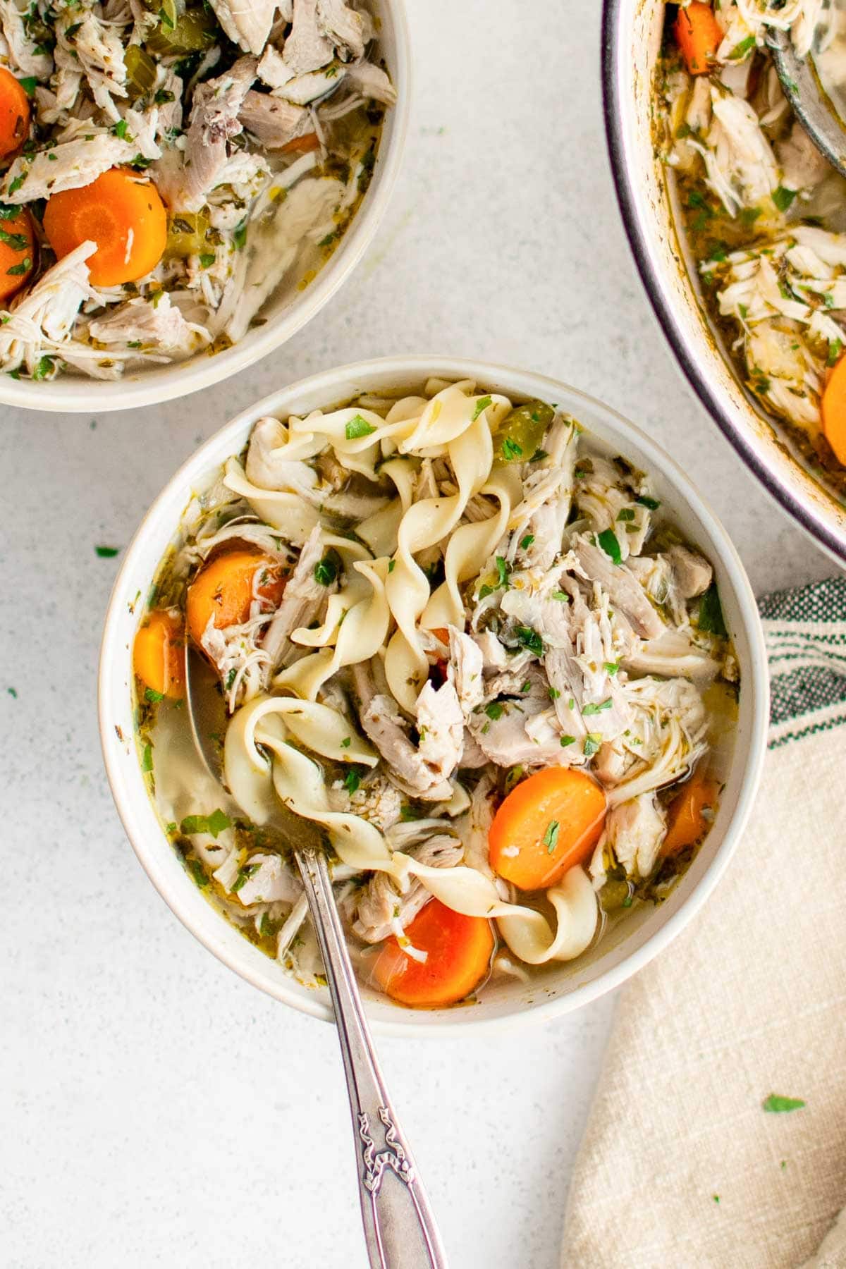 chicken noodle soup in a small bowl with a spoon