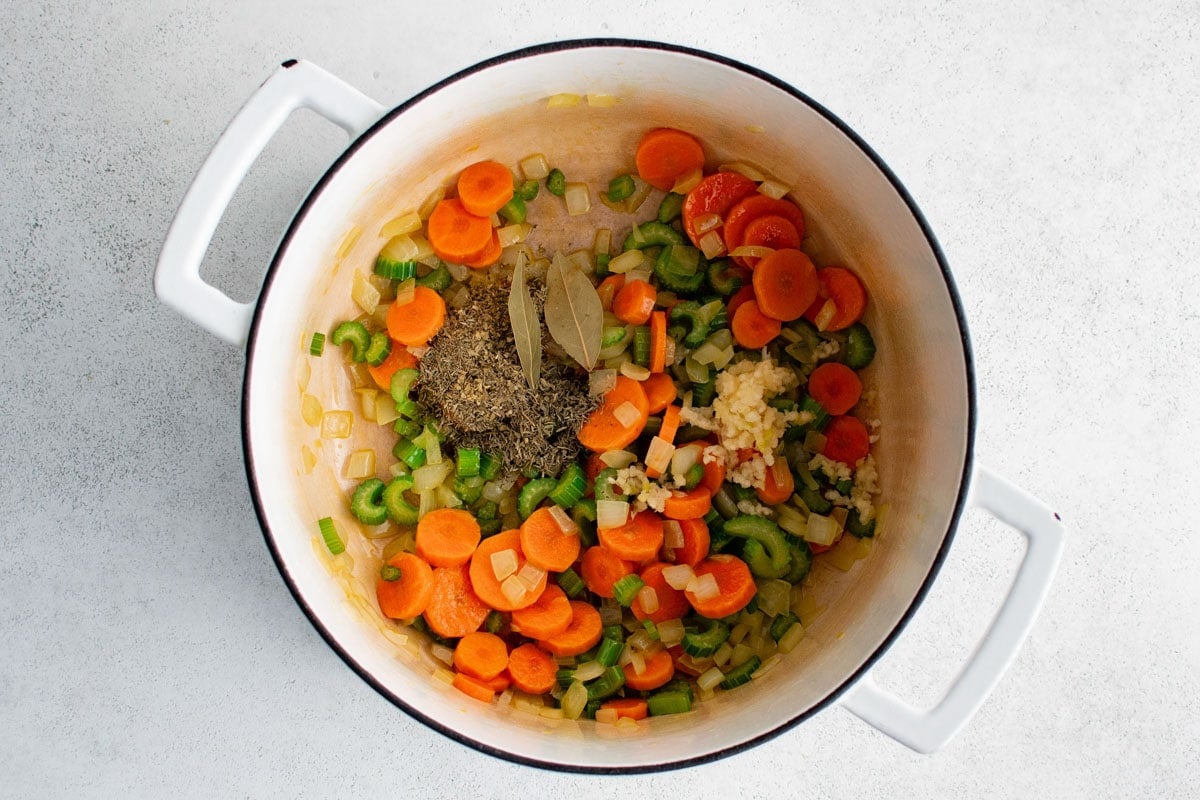 Sliced carrots, celery and onions, bay leaves, minced garlic and dried herbs.