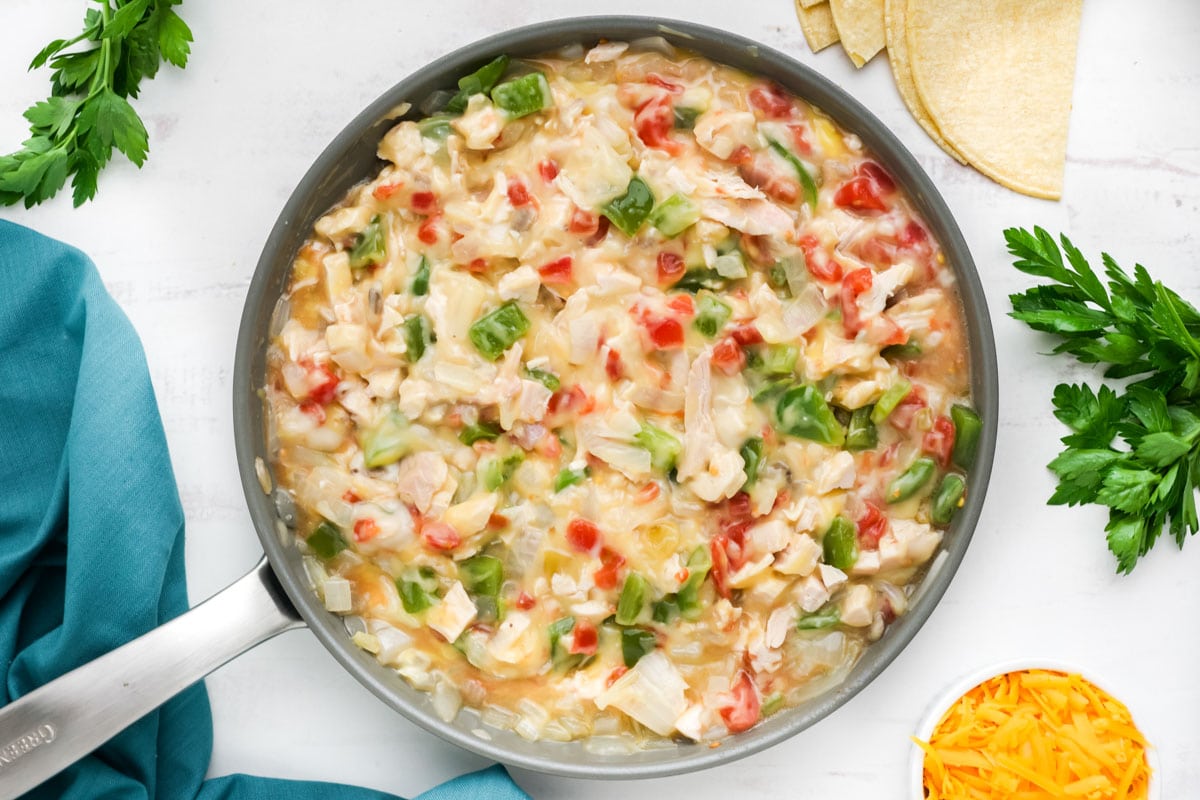 chicken, onions, peppers, tomatoes, condensed chicken and mushroom soups in a skillet.