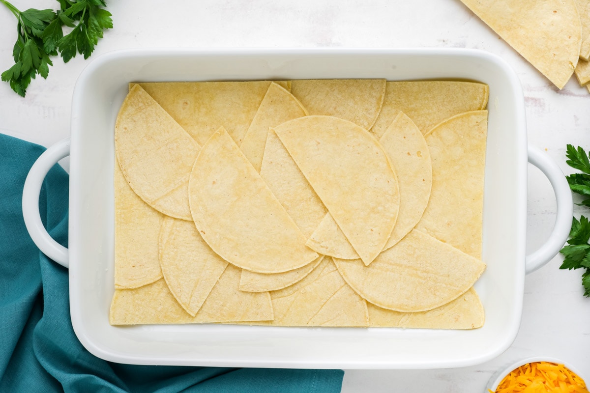 Layer of corn tortillas in a casserole dish.