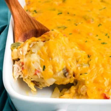 king ranch chicken casserole in a baking dish with a wooden spoon.