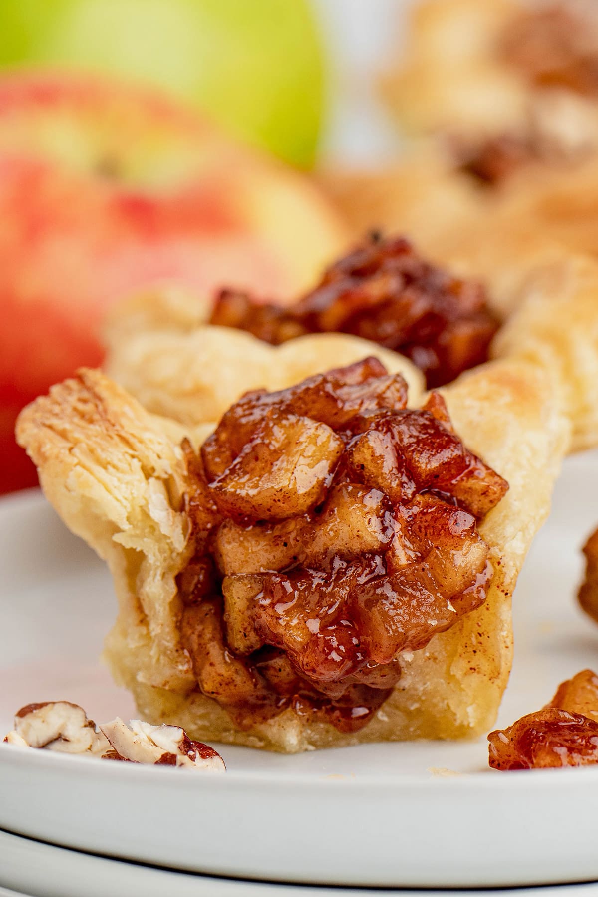 Mini apple tart in piff pastry, sliced in half to reveal the filling.