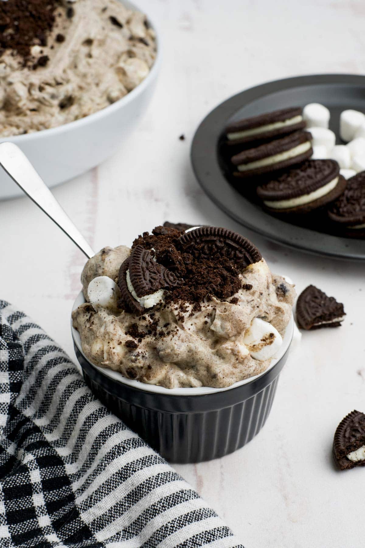 Small black ramekin dish with oreo fluff and a spoon.