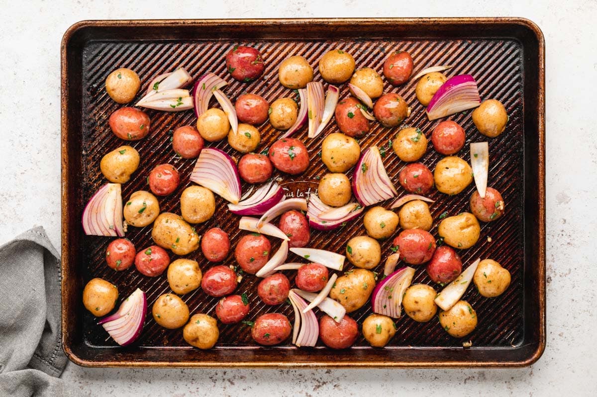 Potatoes and onions on a sheet pan.