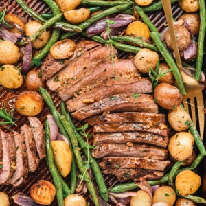 Sliced steak, green beans and potaotes on sheet pan. Image for social media.