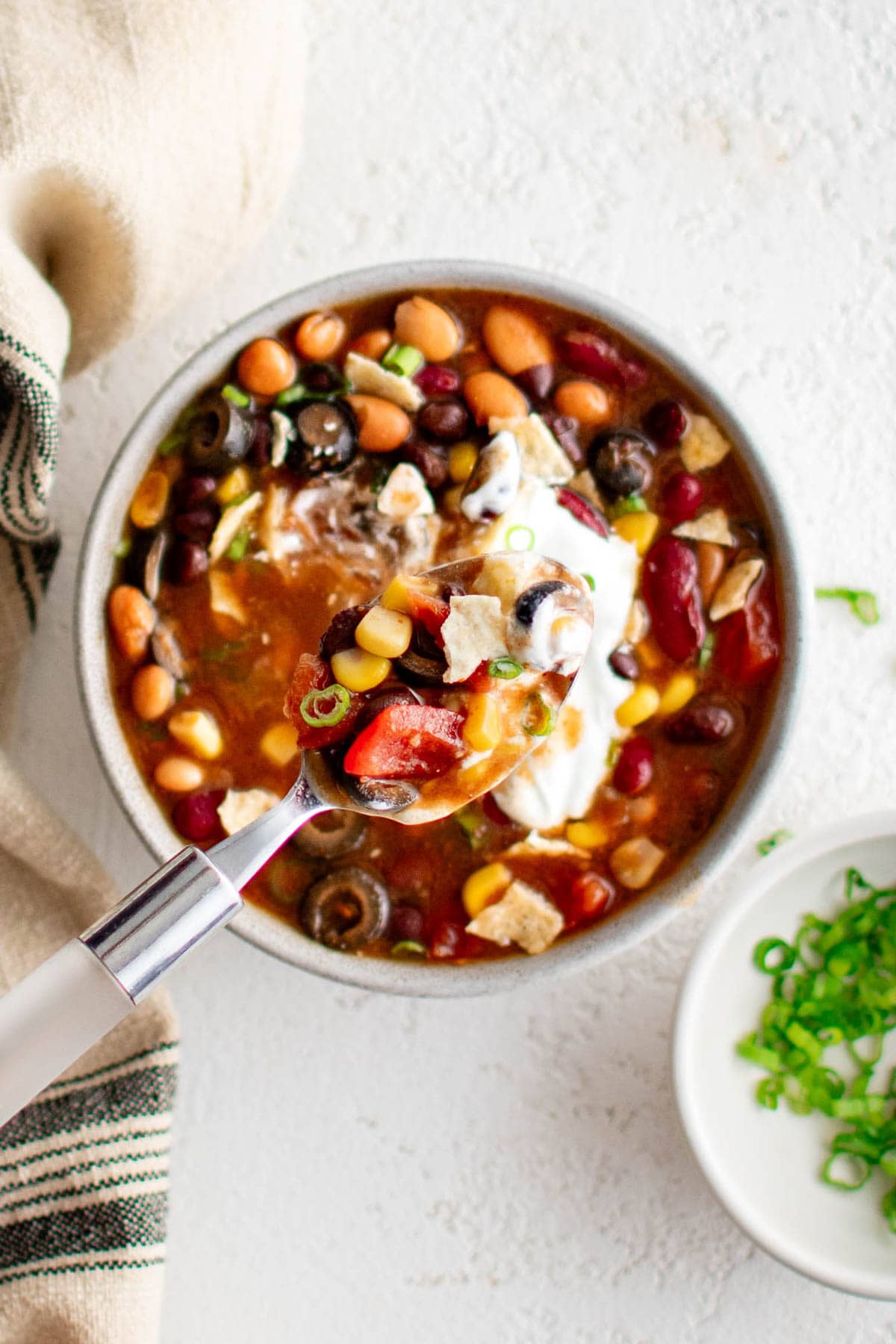 Taco soup with sour cream and cheese toppings.