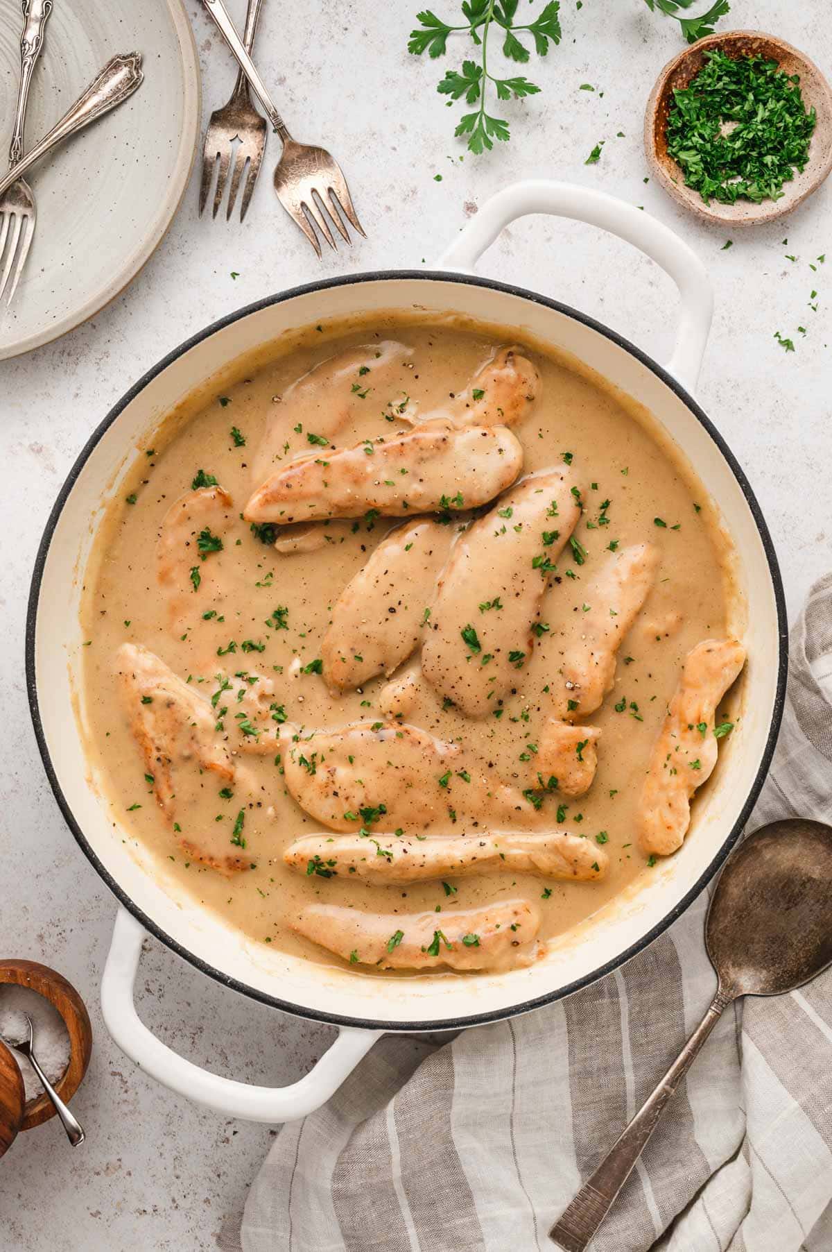 Chicken tenders in gravy in a large skillet.