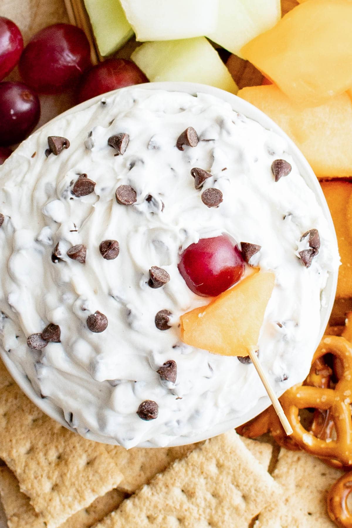 Chocolate chip on a white dip with a cherry and piece of pineapple.