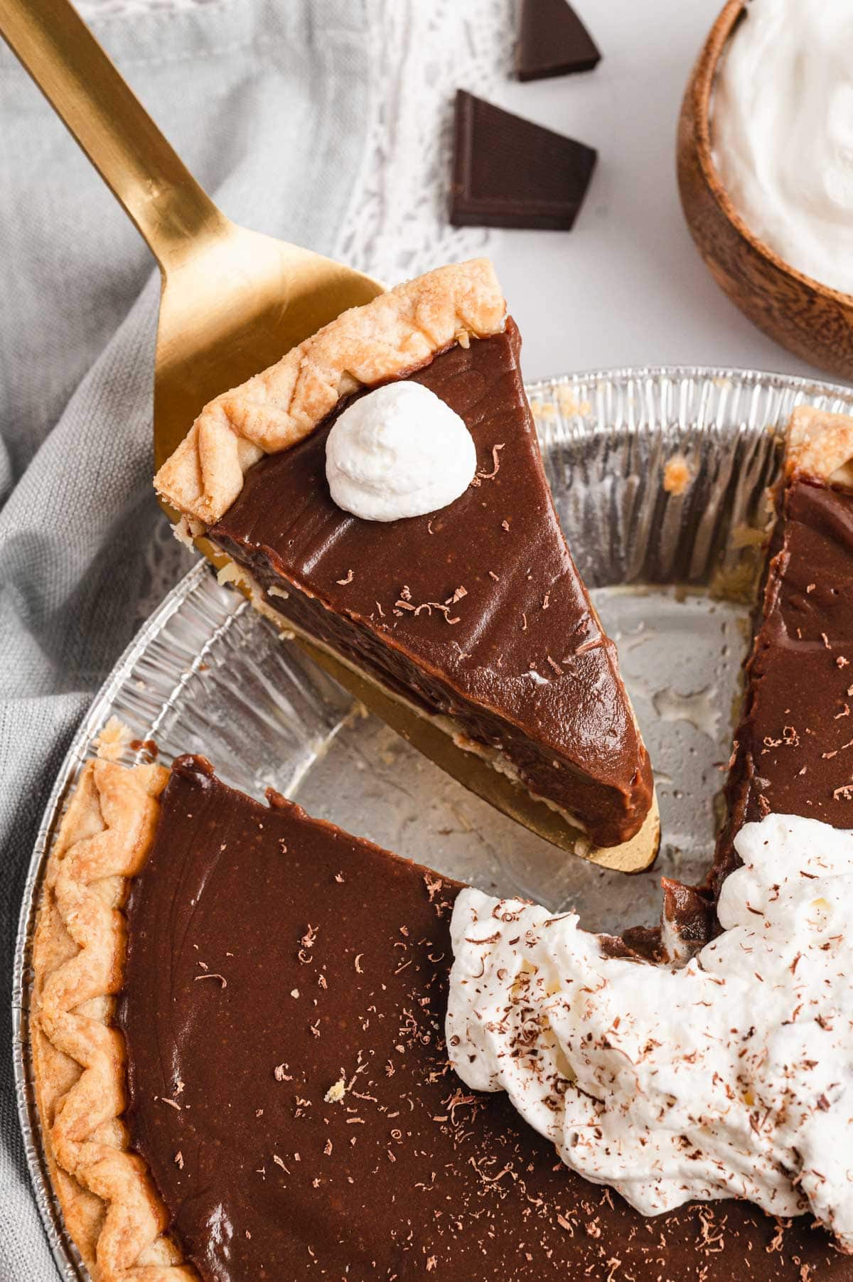 Chocolate pie sliced with whipped cream on top.