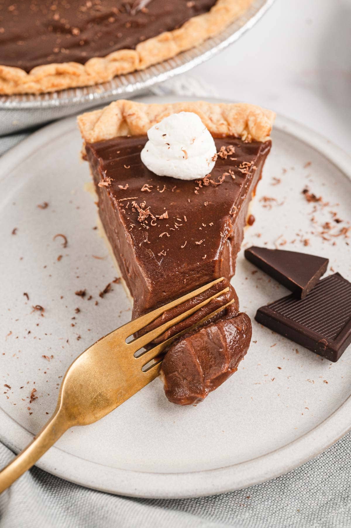 Slice of chocolate pie on a small plate with a fork. 