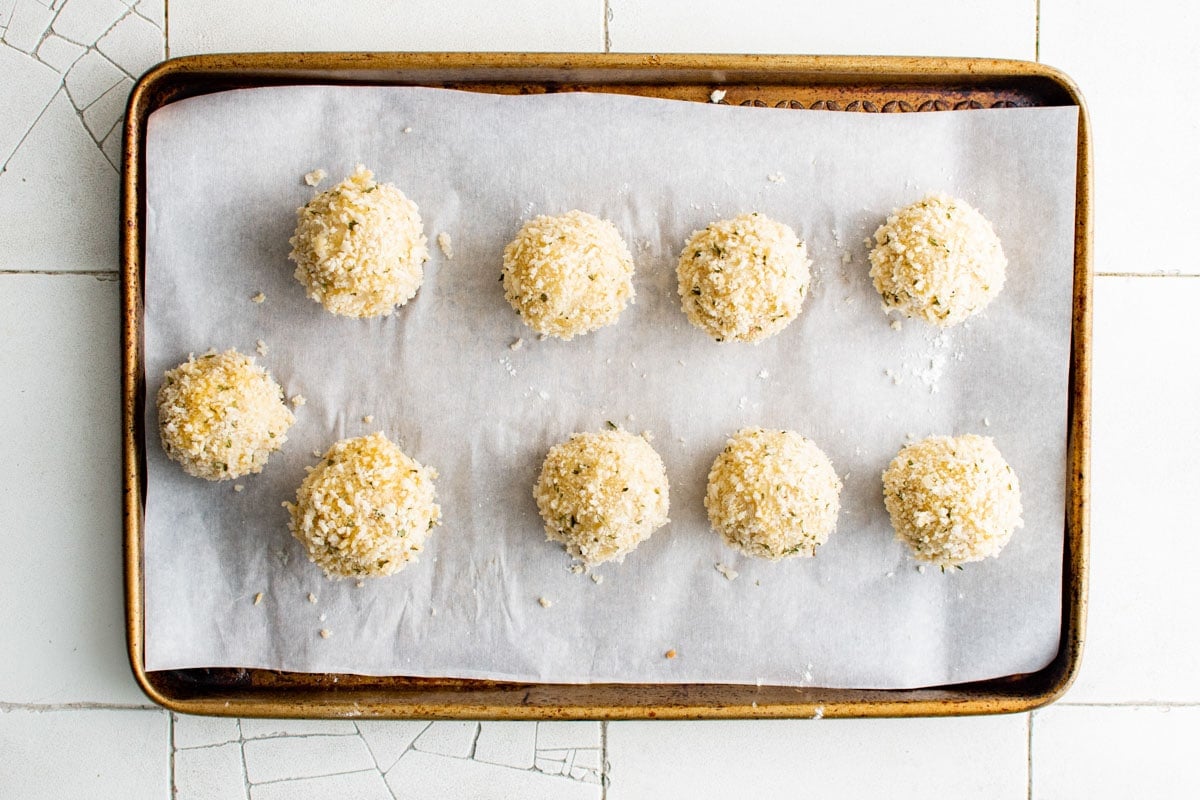 Panko coated potato balls on a sheet tray.