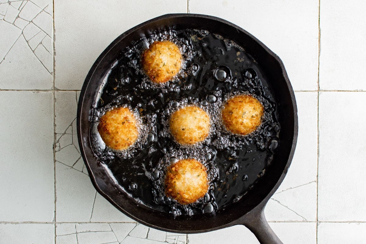 Pan of oil frying mashed potato balls.