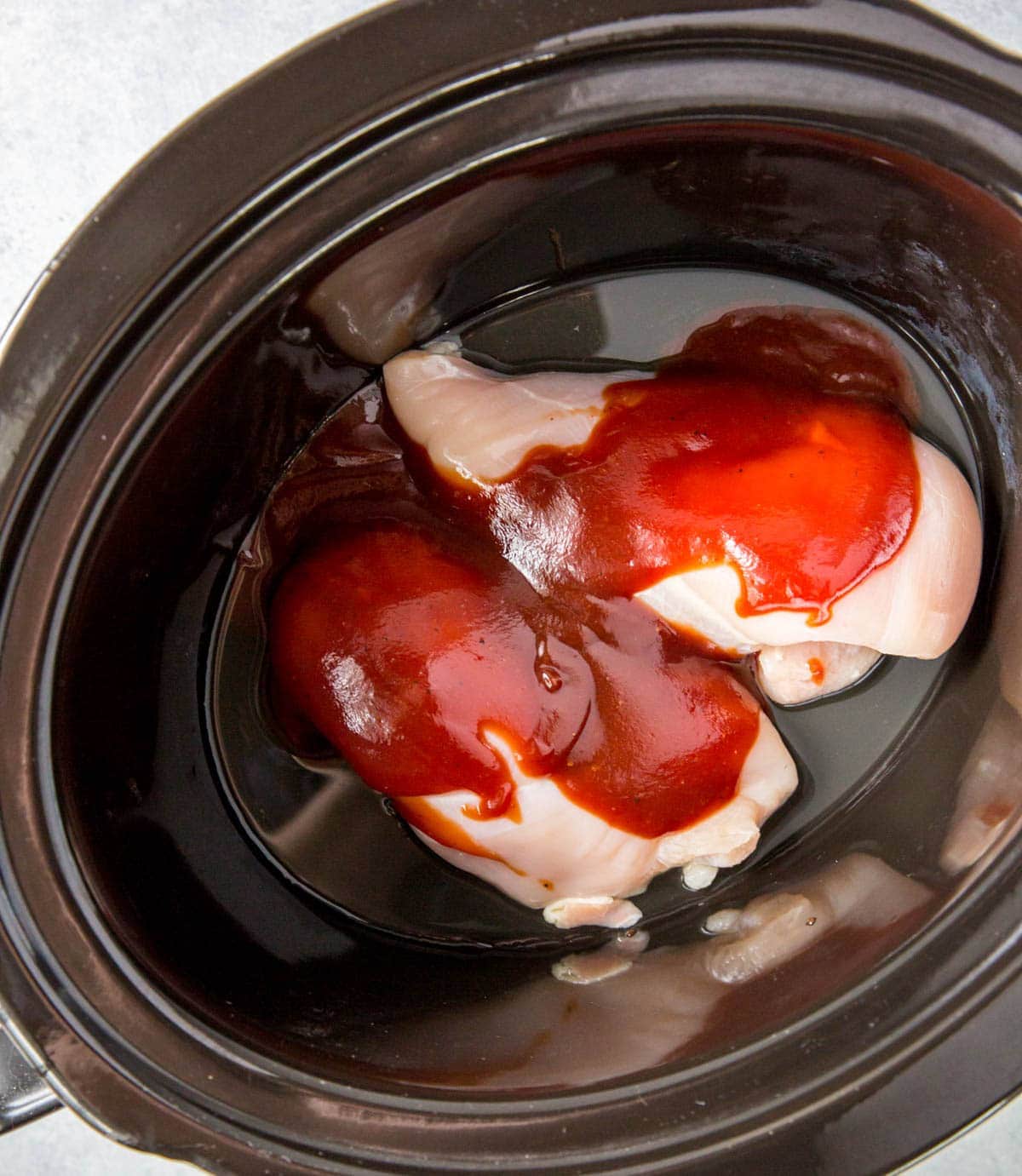 chicken breasts and bbq sauce in slow cooker