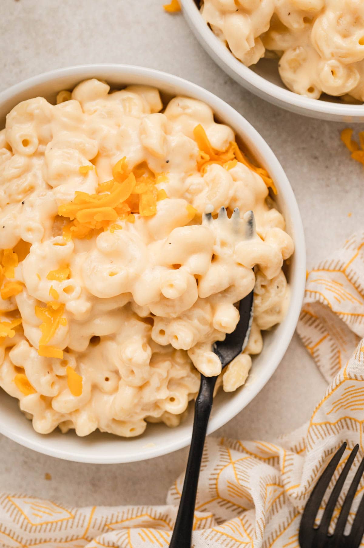 Bowl of mac and cheese with a black fork.