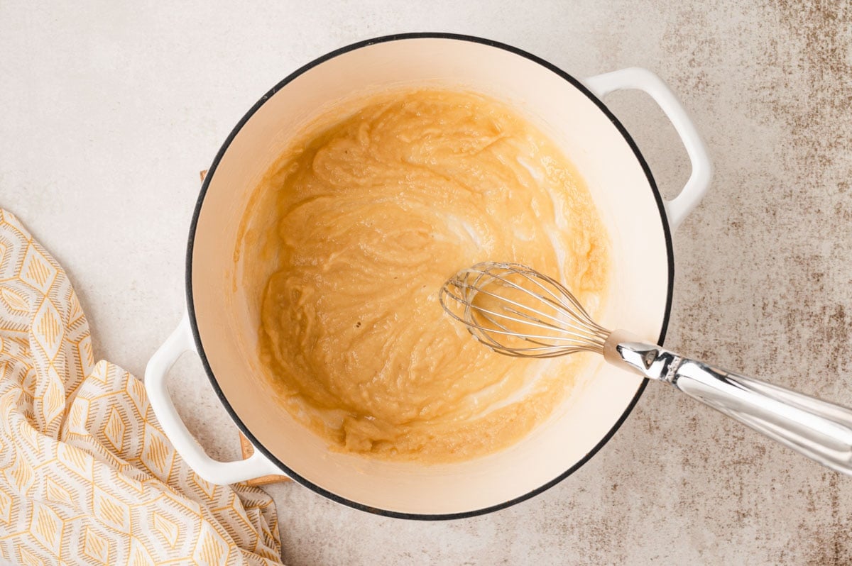 A roux made with flour and butter in a large pot, with a whisk.