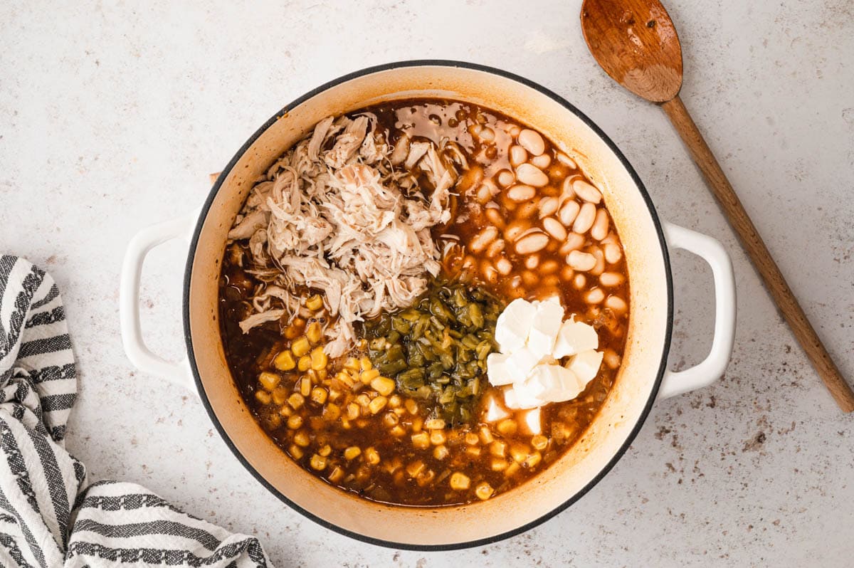 chicken, green chiles, corn and beans in a red broth.