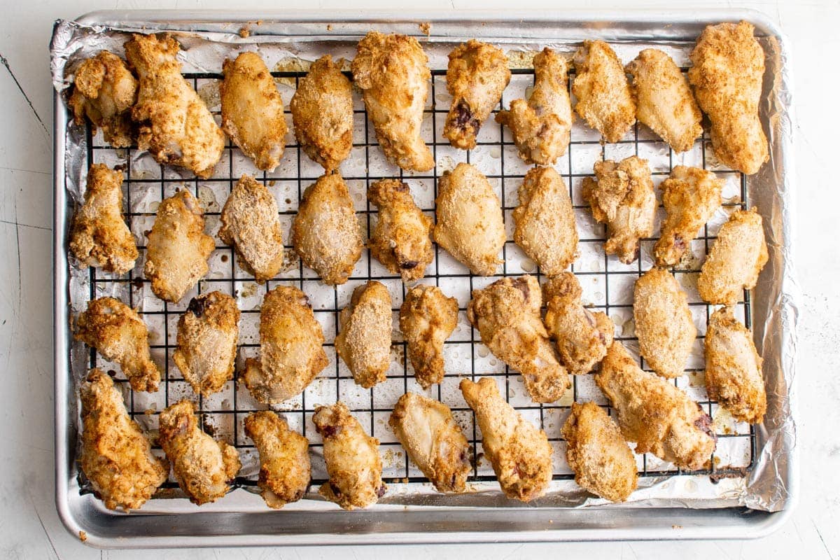baked buffalo wings on a wire rack and baking sheet
