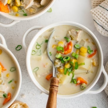 Bowls of chicken soup with creamy broth and vegetables.