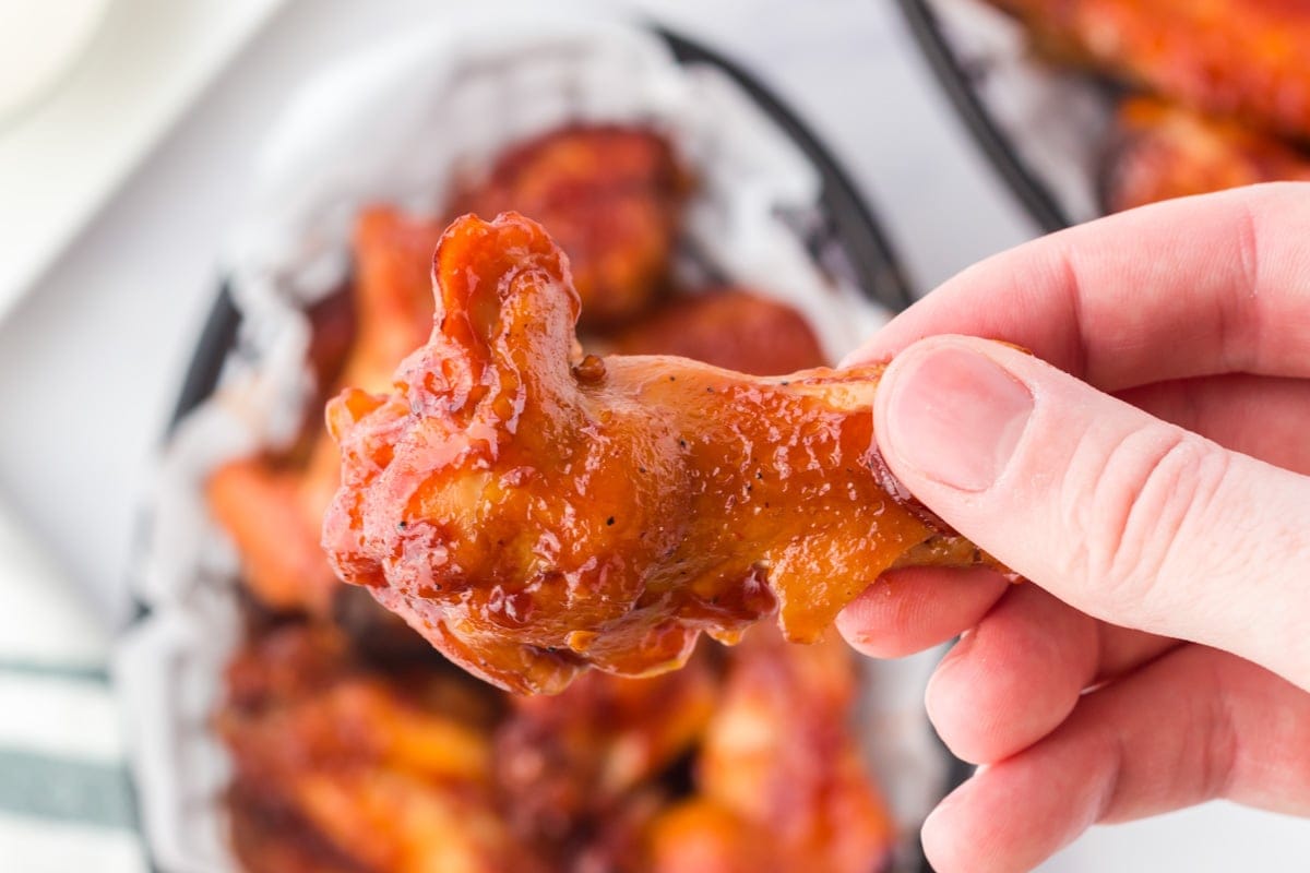 chicken wings held in someone's hand