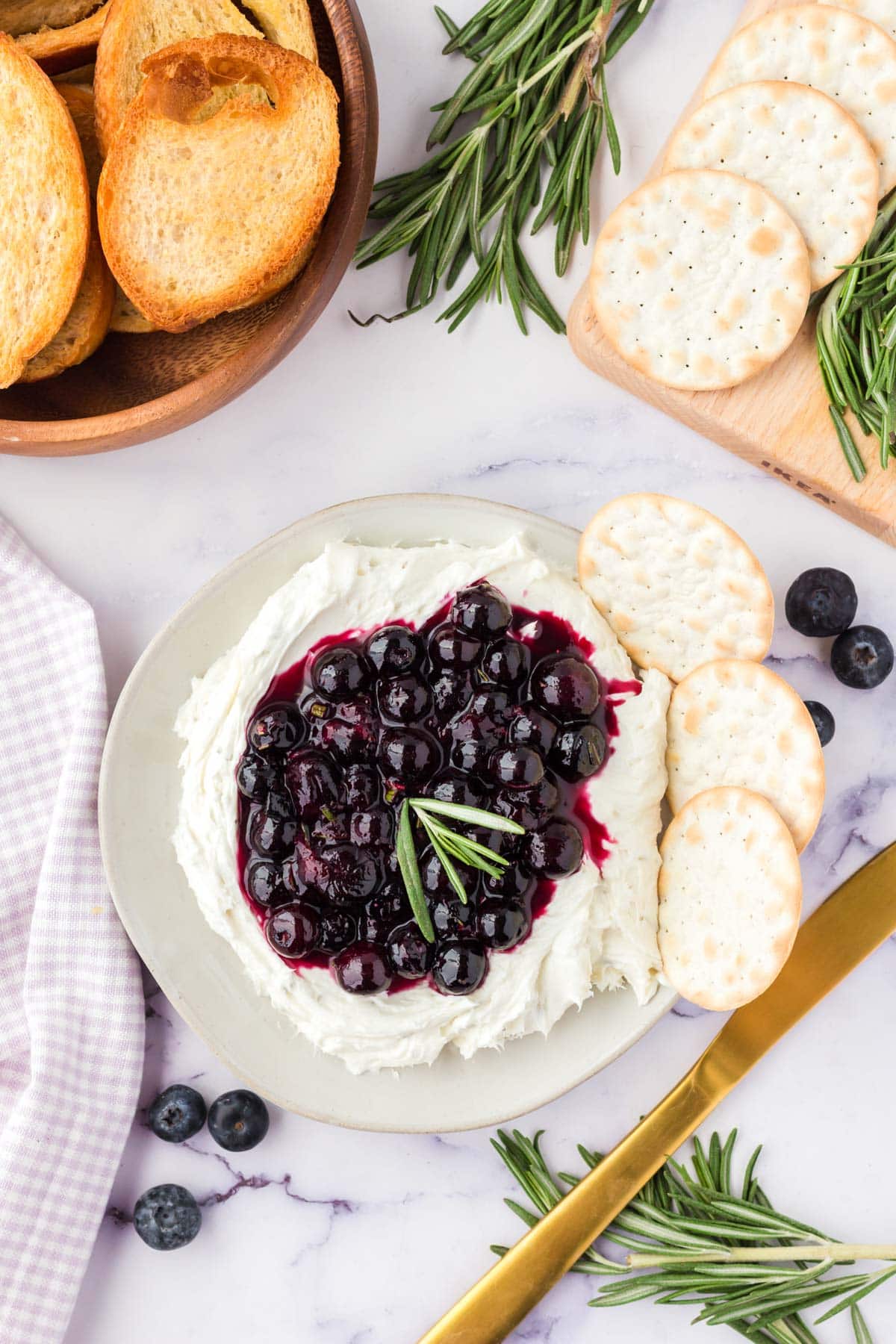 Goat cheese blueberry spread on a white platter, with crackers. 