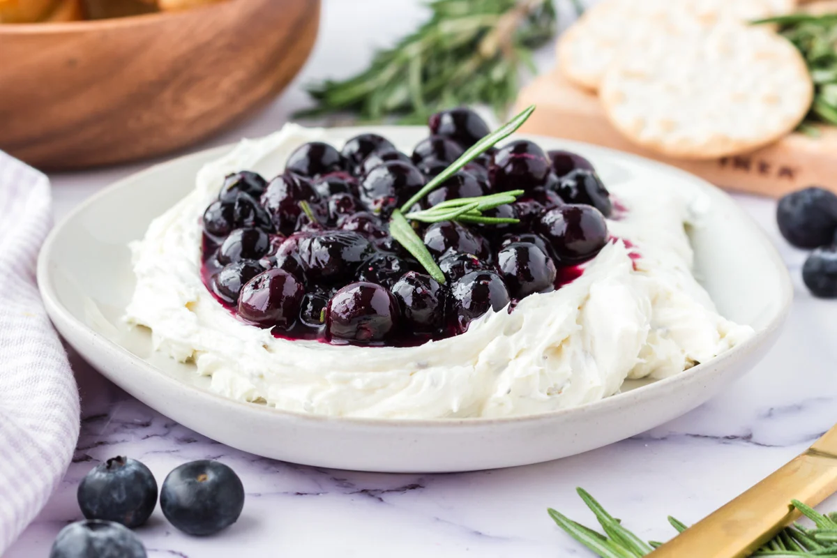 Blueberry goat cheese spread on a white plate.