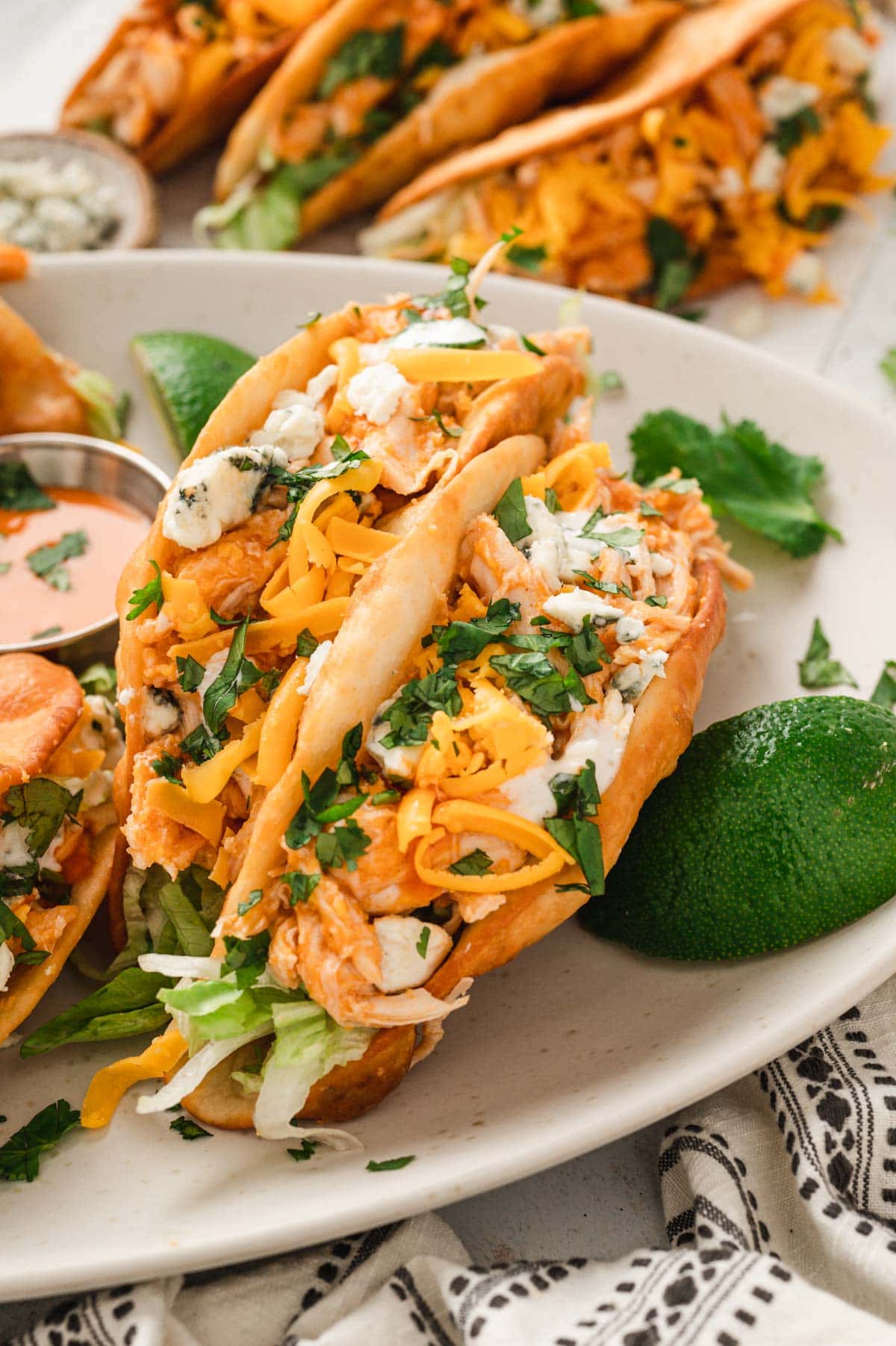 Close up of 2 buffalo chicken tacos on a white plate