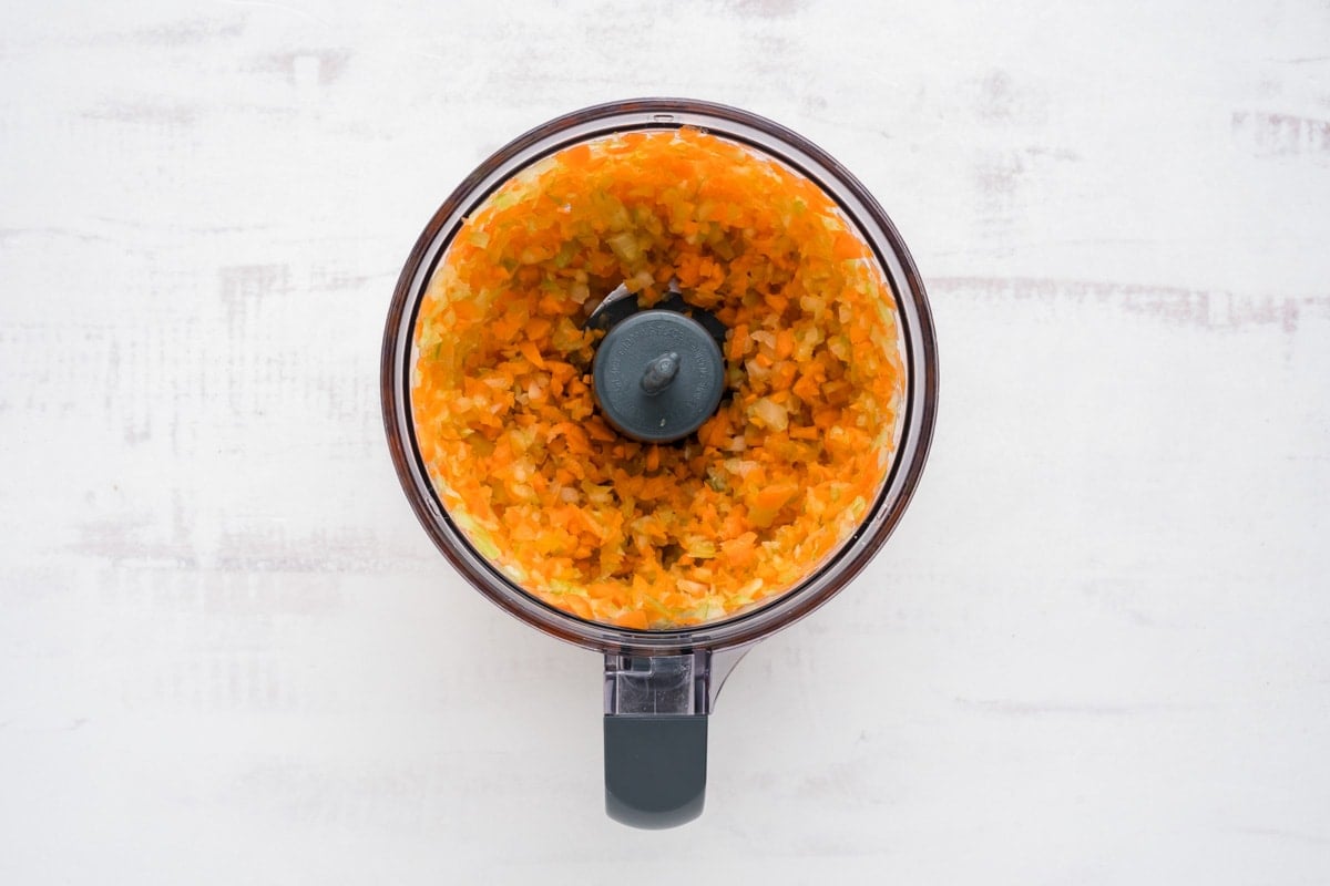 Chopped carrots and celery in a food processro.