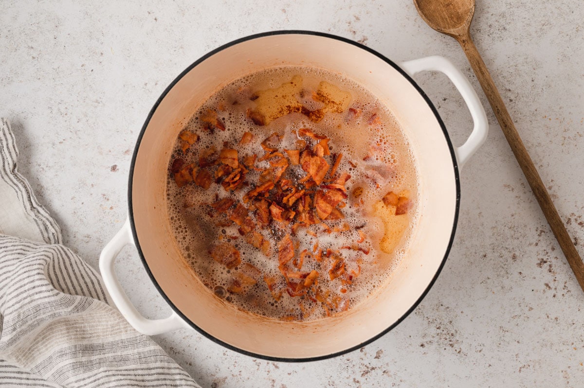 Diced bacon cooking in a large pot.