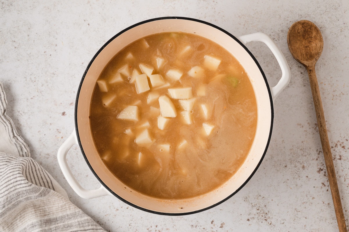 Broth and diced potatoes in a large pot.