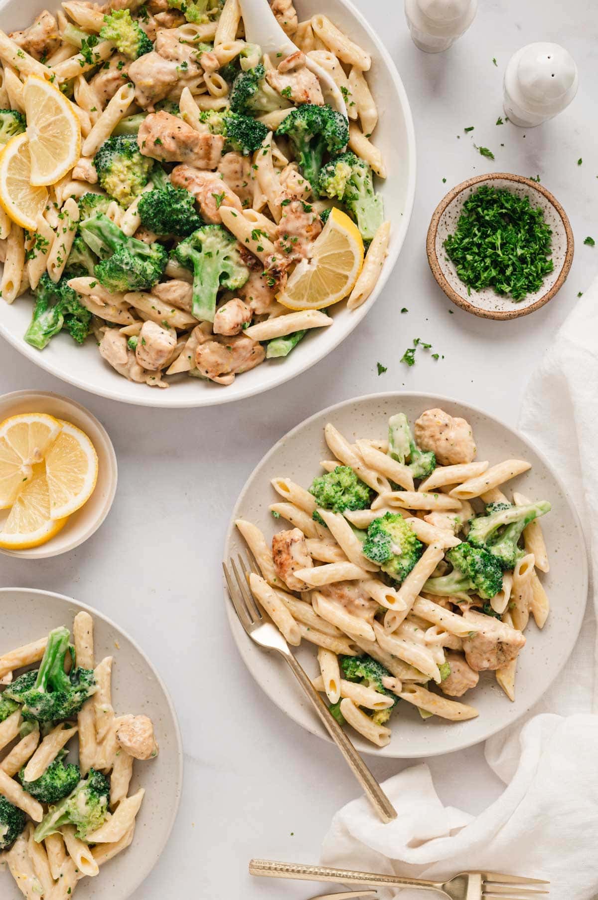 Chicken broccoli and pasta on individual plates.