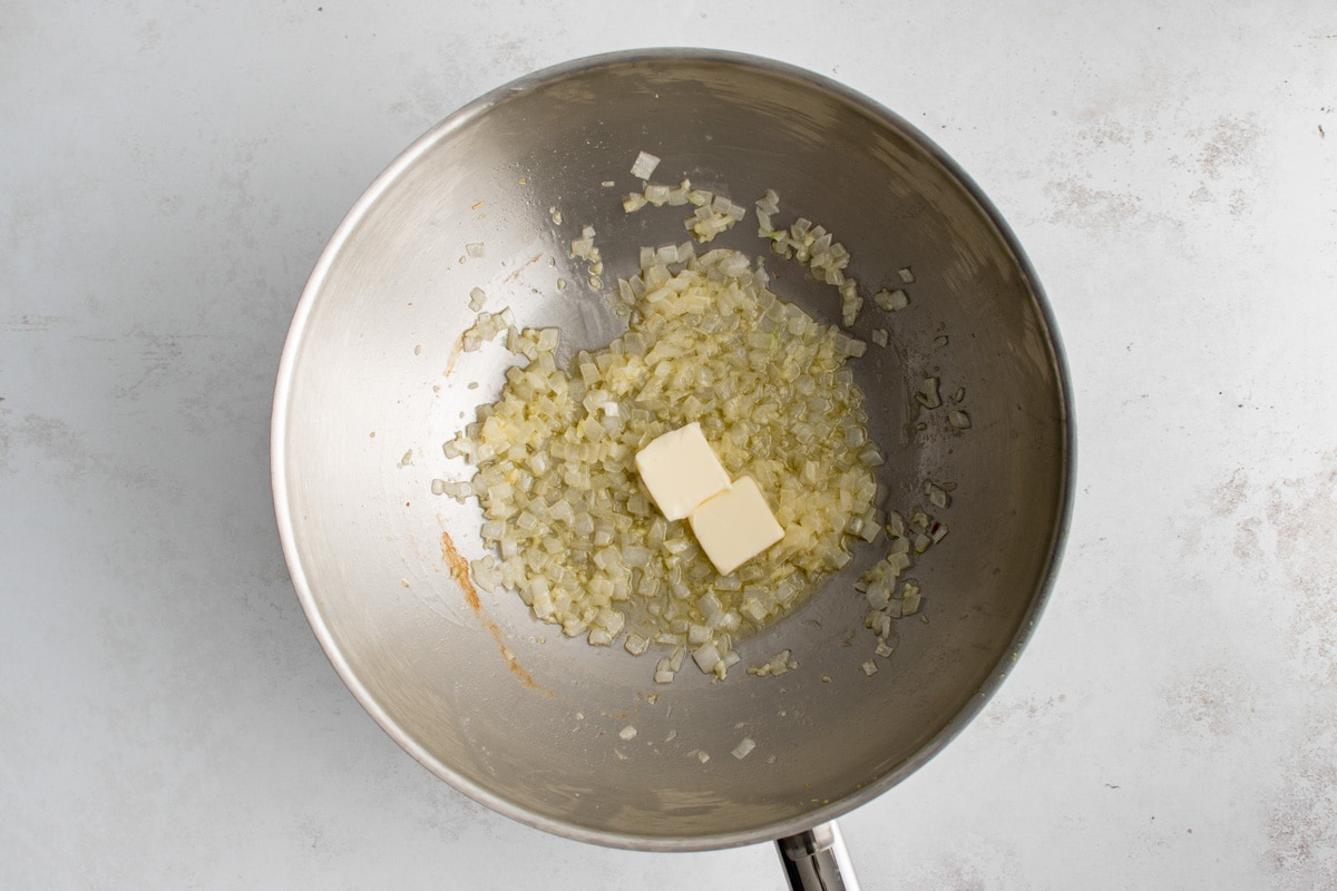 Dice cooked onions and a pat of butter in a wok.