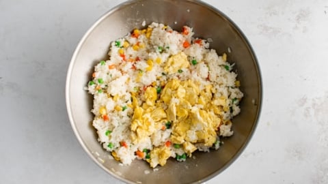 Rice, vegetables and scrambled egg in a wok.