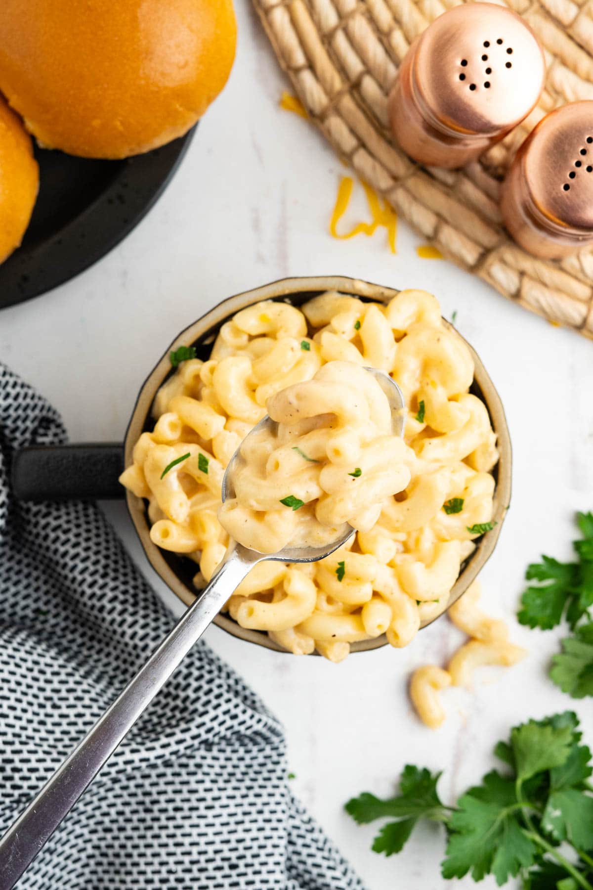 Mac and cheese in a mug with a spoon.