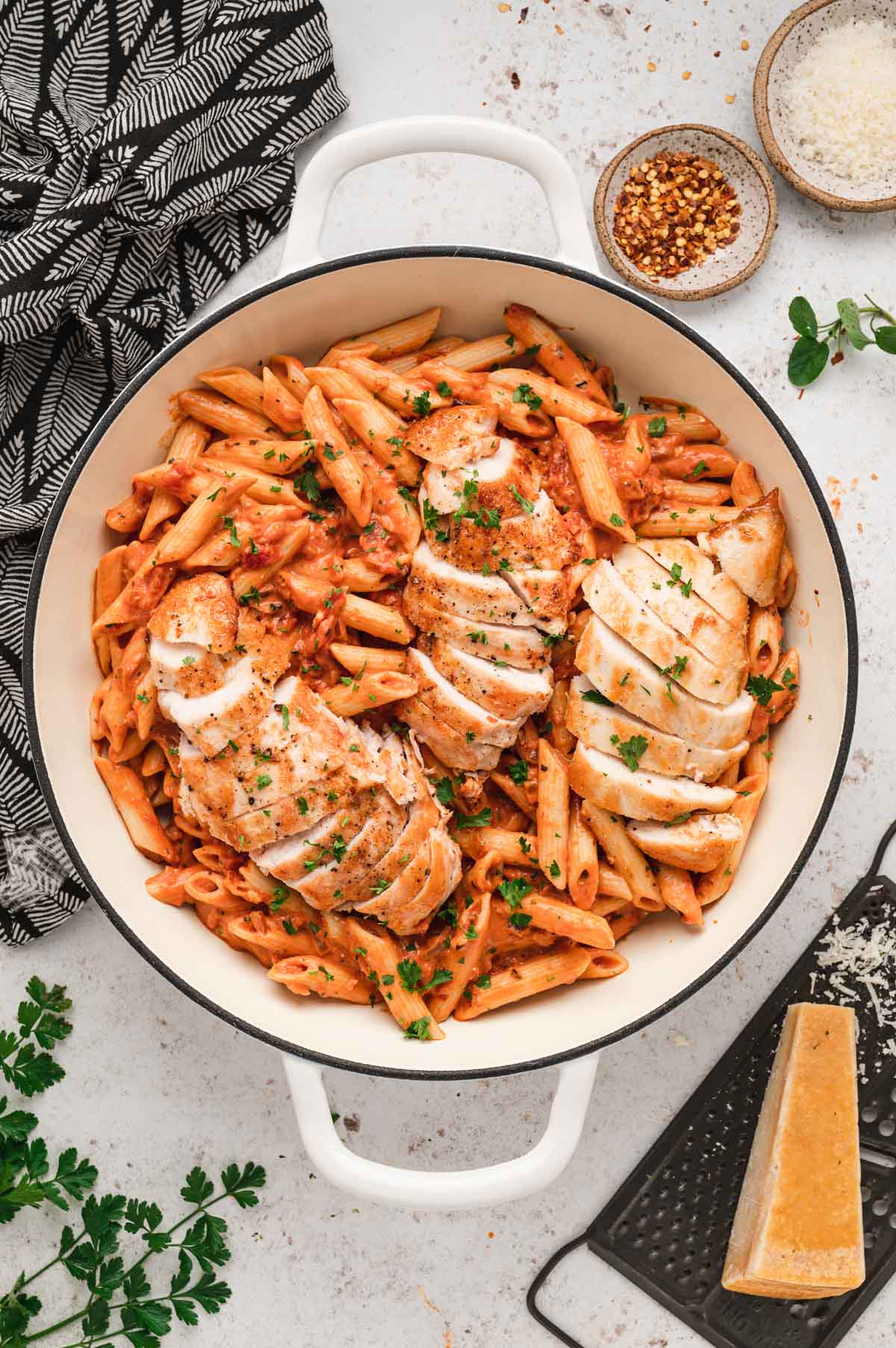 Spicy chicken pasta in a white skillet.