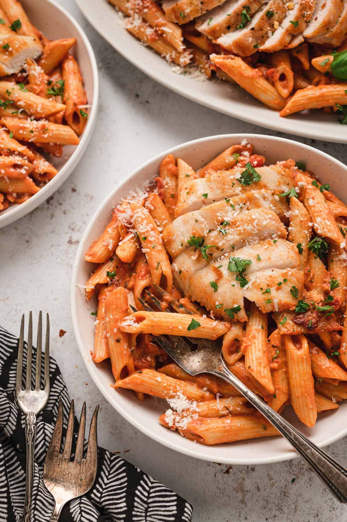 A serving of spicy chicken pasta on a small white plate.