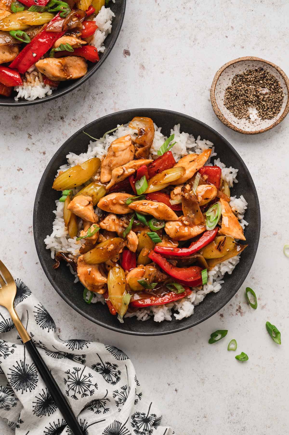 Black pepper chicken and veggies over rice.