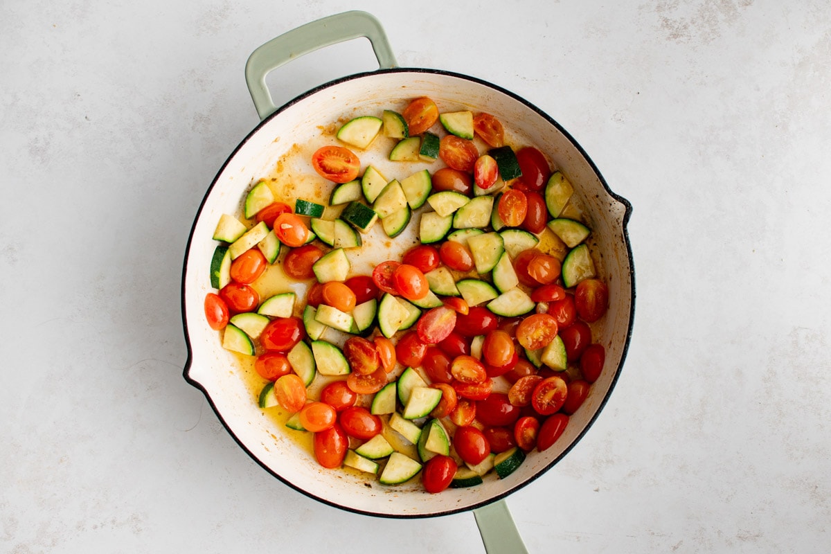 Tomatoes and zucchini and carrots in a skillet.