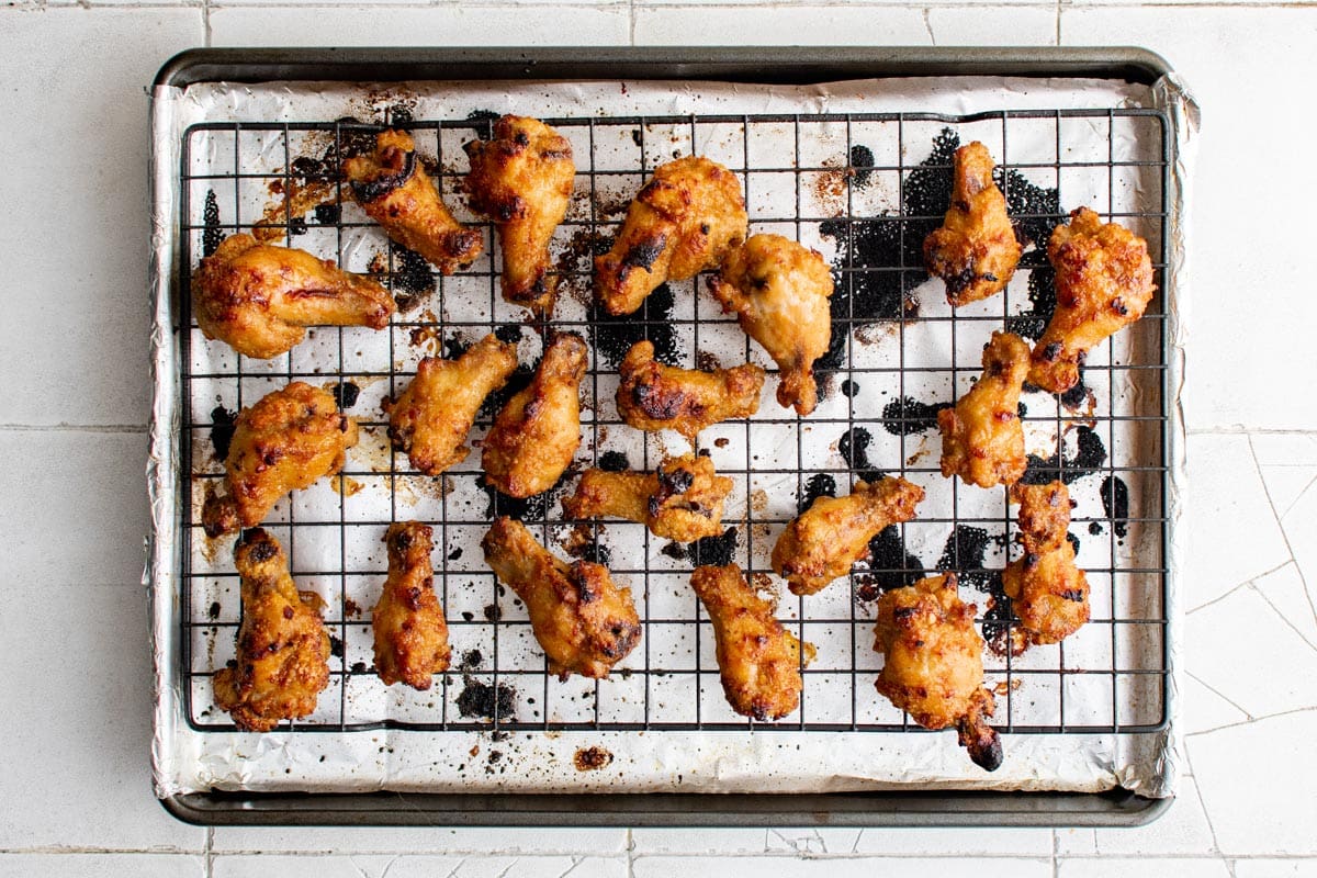 Double baked chicken drumettes on a wire rack and baking sheet.