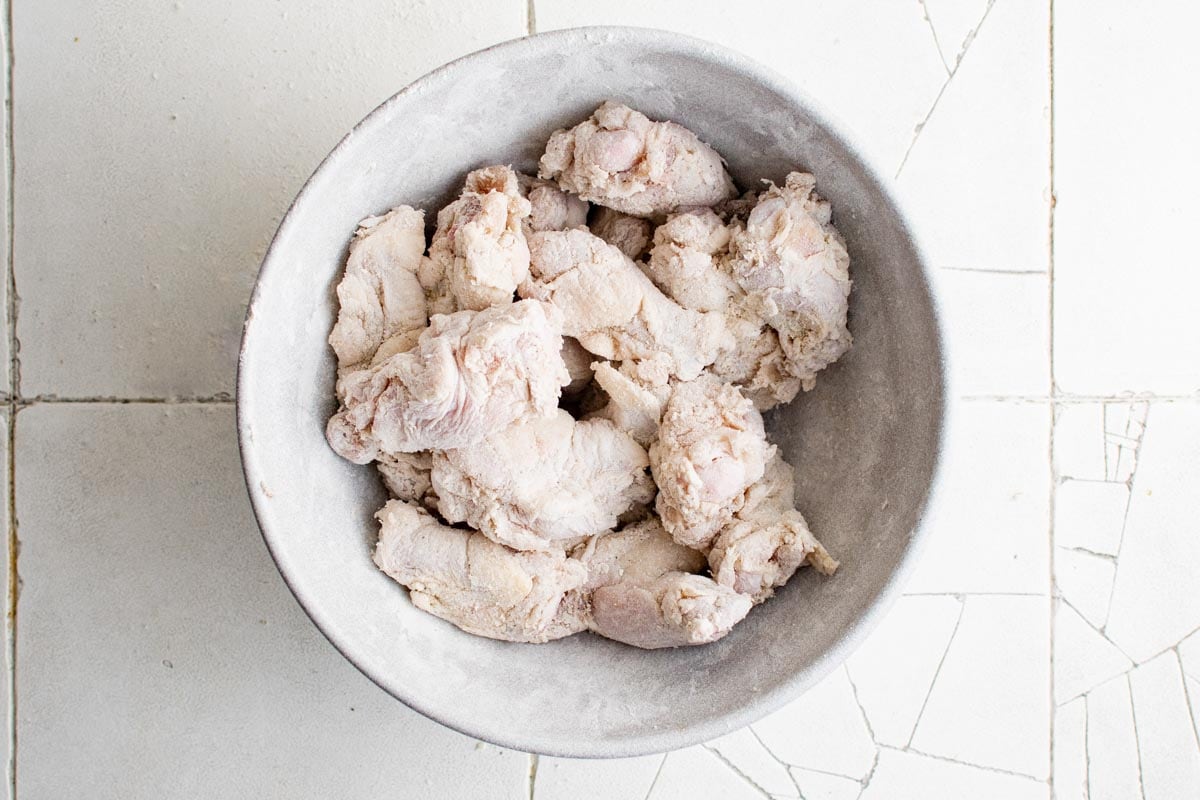chicken wings in a bowl with flour coating.