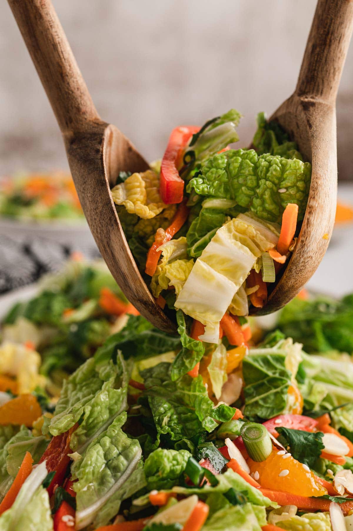 Napa cabbage salad in salad tongs.