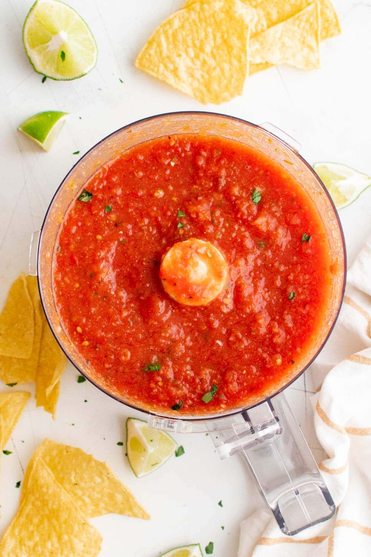 salsa in a food processor, tortilla chips, limes