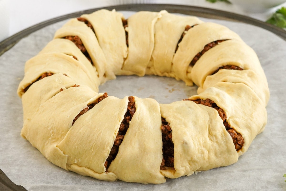 taco ring with meat and crescent dough before baking