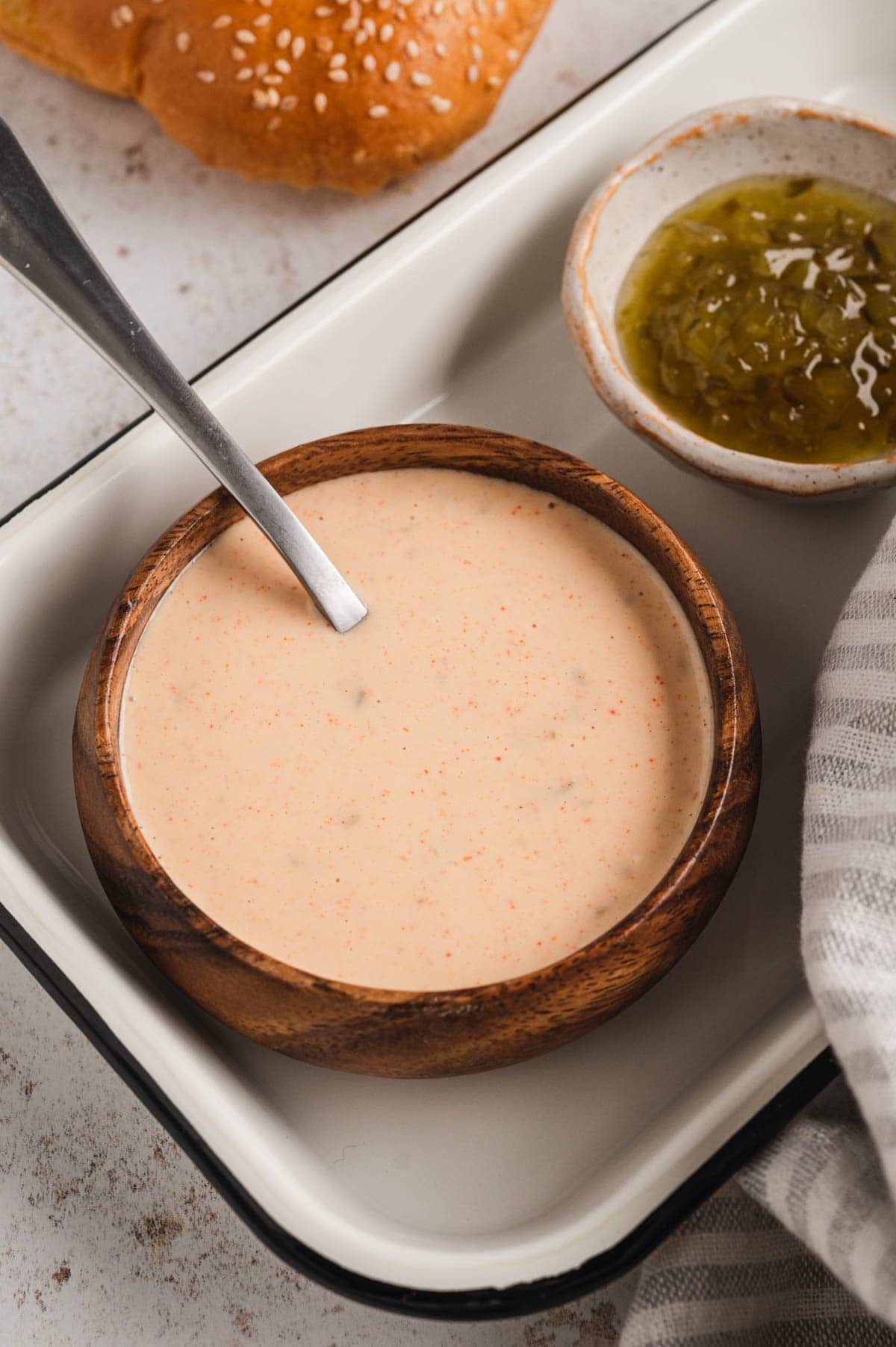 Big mac sauce in a wood bowl with a metal spoon.