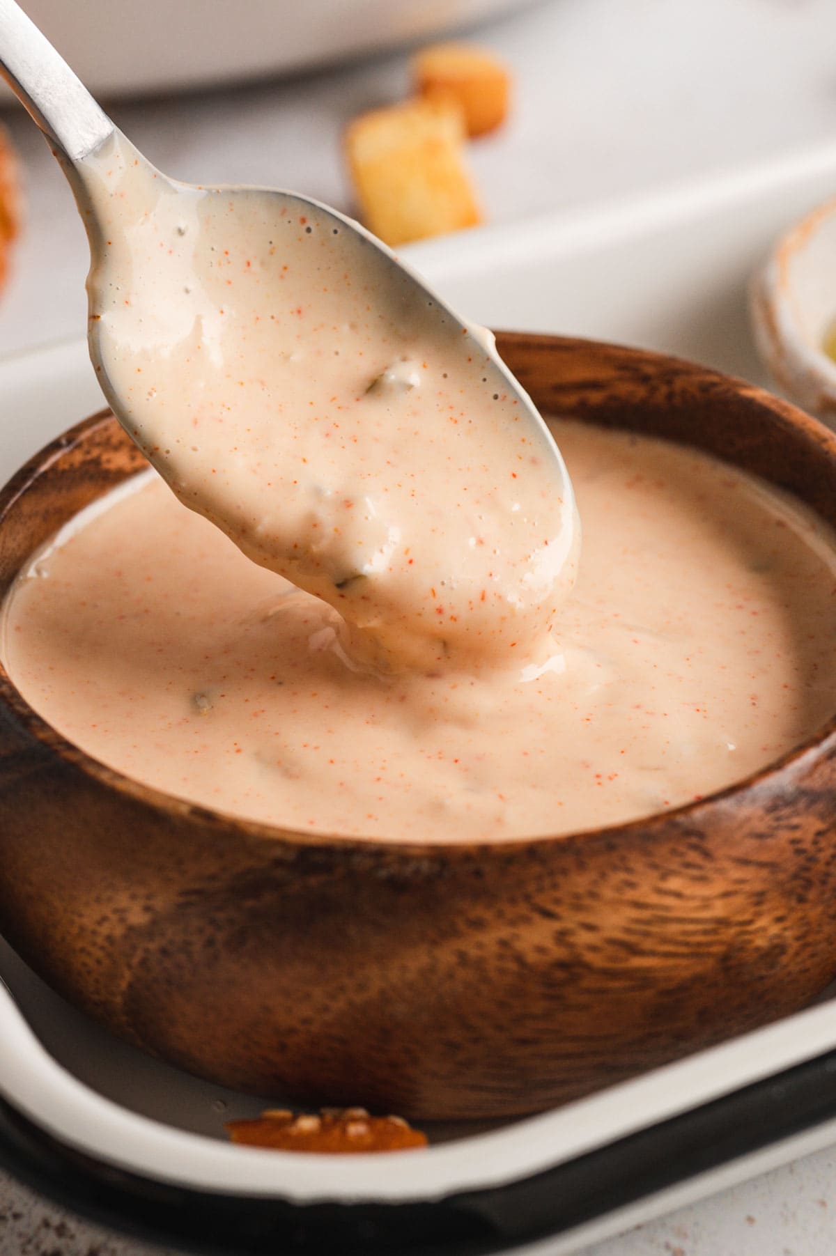 Big mac sauce in a wood bowl with a spoon.