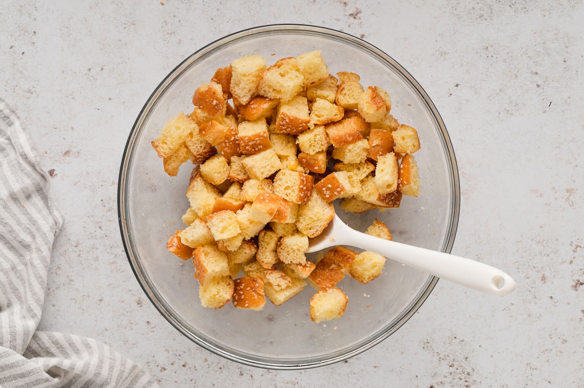 Cubes of bread in a bowl with a spoon