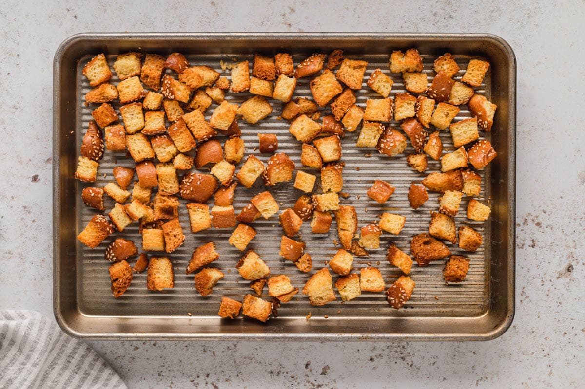 Toasted bread cubes on a baking sheet.