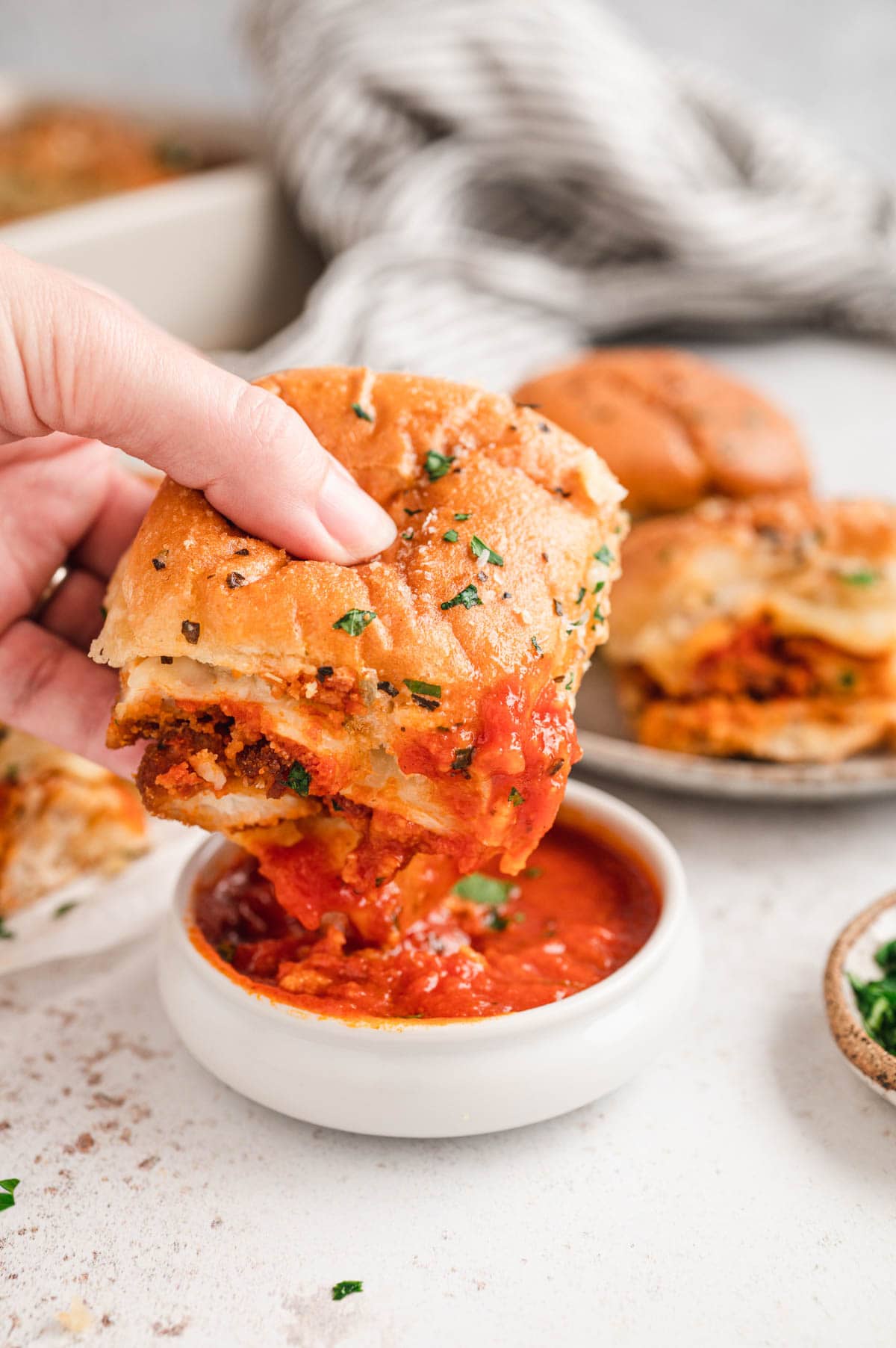 Dipping a chicken parmesan slider in marinara.